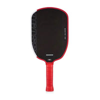 White background, front view of a red and black paddle with a textured face and a red perforated grip.