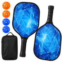 Two pickleball paddles printed with a blue constellation pattern on a dark face, shown with two orange balls, two blue balls and a black zippered carry case.