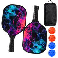 Two black pickleball paddles printed with a pink, purple and teal low-poly network pattern, shown with a zippered carry case, two orange balls and two blue balls.